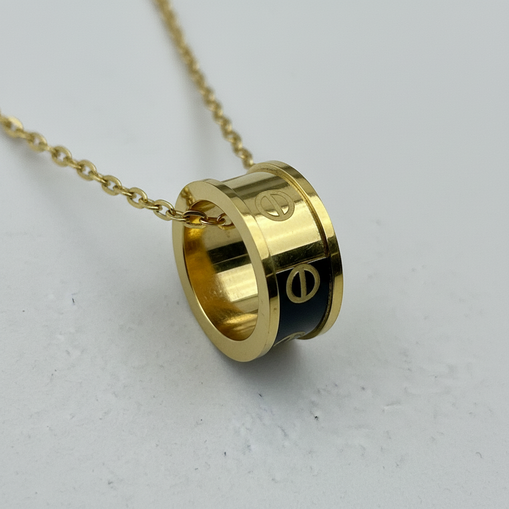 Closeup detail of cylindrical pendant showing gold finish and black enamel