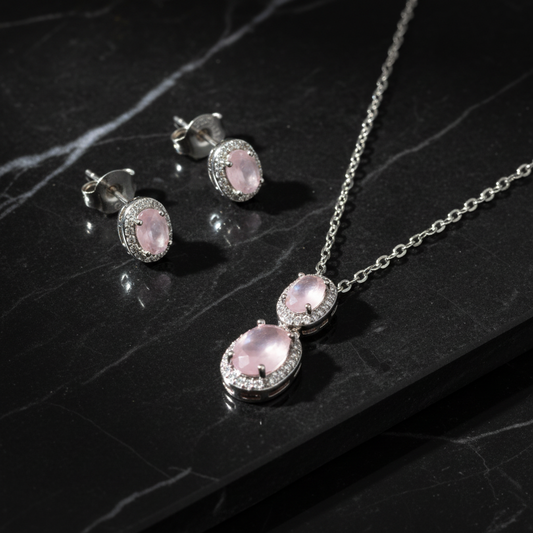 Rose quartz jewelry set on black marble with dramatic lighting